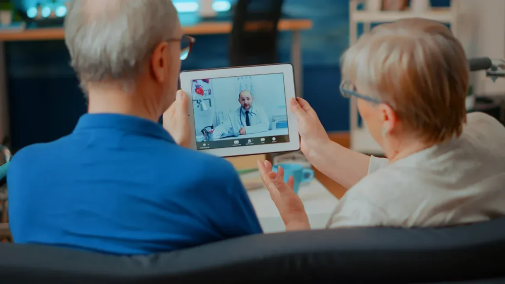 Two people looking at doctor on tablet